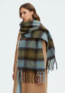 Detail of blue and green checkered scarf with fringe and a handmade label on the edge
