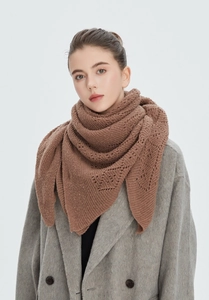 Detail of tan openwork knit shawl showing the intricate bohemian crochet pattern