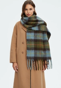 Detail of soft thick plaid scarf with colorful vintage patterns and long tassels