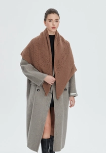 Detail of a brown knit shawl with intricate diamond hollow-out patterns on a wool coat