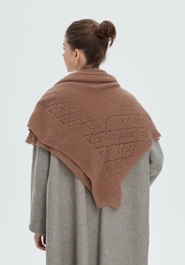Detail of caramel brown knit shawl with hollow geometric crochet patterns on wool coat