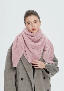 Close-up of elegant hollow-out knitted pink shawl paired with wool coat texture