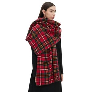 Red tartan plaid oversized scarf with classic check pattern worn over a black winter coat