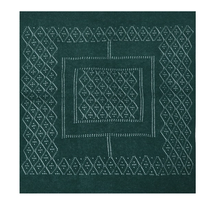 Close-up of forest green knit shawl featuring white geometric diamond hollow patterns