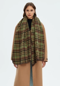 Detail of a thick green plaid Christmas scarf paired with a classic camel wool coat