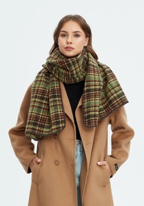 Detail of a thick green plaid Christmas scarf paired with a camel wool coat and label