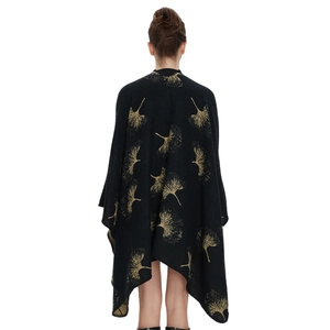 Black knit poncho with gold ginkgo leaf pattern featuring reversible split design
