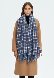 Detailed texture of blue plaid scarf with long fringe on camel wool coat for winter