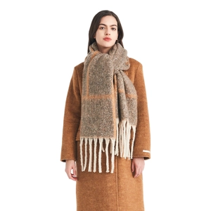 Oversized beige and brown plaid scarf with long fringes over a camel wool coat