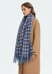 Detail of blue plaid scarf with fringes and handmade label on wool blend fabric