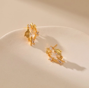 Irregular geometric gold earrings with textured vertical lines and clear zircon stones