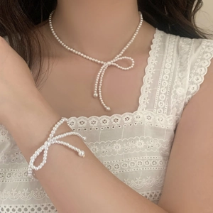 Ensemble élégant collier et bracelet en perles avec breloque nœud et fins glands