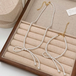 Elegantes Perlen-Halsketten- und Armband-Set mit Schleife auf einem Schmuck-Display