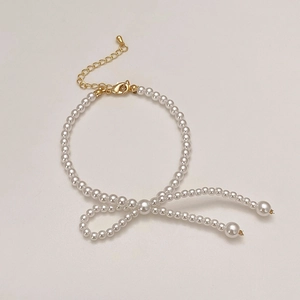 Bracelet en perles élégant avec détails dorés disposé en forme de nœud créatif