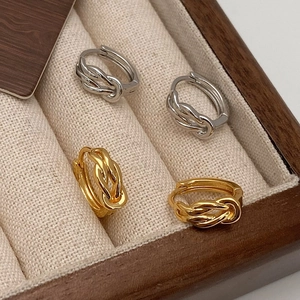 Polished gold and silver twisted knot hoop earrings set in a vintage jewelry box