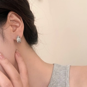 Elegant silver leaf drop earrings with sparkling zircon crystals on a female model