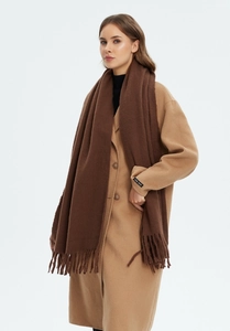 Detail of dark brown tassel scarf paired with camel wool coat featuring handmade label
