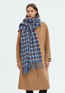 Detail of blue plaid oversized scarf with soft tassels and thick knitted texture