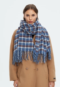 Detail of blue and brown plaid scarf with fringe paired with a winter wool coat