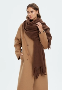 Close-up of brown tasseled cashmere-like scarf paired with a camel wool coat for winter