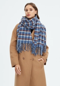 Detailed texture of blue and beige plaid winter scarf with fringe on camel coat