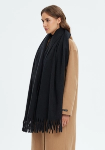 Detail shot of black solid cashmere-like scarf with long tassels and handmade label
