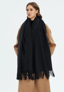 Close-up of black oversized scarf with tassels showing thick texture and drape