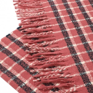 Macro detail of soft pink and blue plaid scarf fabric with handmade fringe tassels