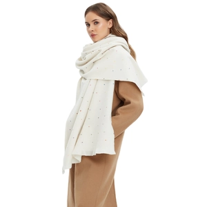 Witte wintersjaal met regenboogstippen gedragen met een camelkleurige wollen jas voor dames