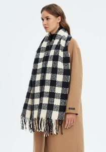 Close-up of black and white buffalo check scarf with long fringe tassels and thick knit texture