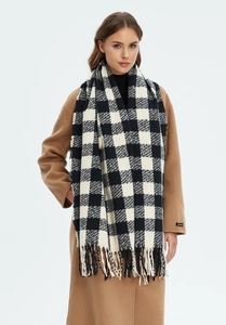 Close-up of black and white checkered scarf featuring hand-made label and long tassels