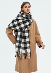 Close-up of black and white checkered scarf with tassel detail on a winter wool coat