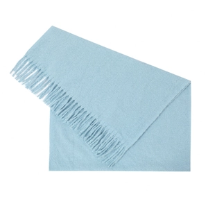 Close-up of light blue knitted scarf texture with detailed soft tassel fringes