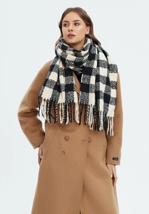 Detail of black and white checkered scarf with long tassels and camel wool coat