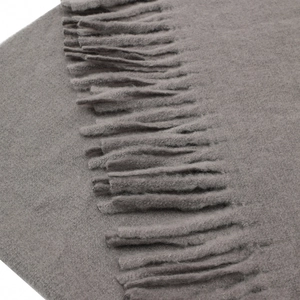 Close-up of grey pashmina shawl showing soft cashmere texture and neat tassel details