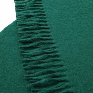 Detail view of forest green cashmere scarf featuring soft texture and neat tassel fringe
