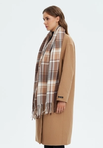 Detail shot of khaki tartan scarf with fringe paired with a handmade camel wool coat