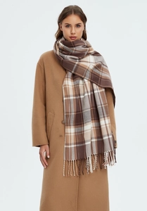 Close-up of khaki plaid scarf with fringe tassels showing thick soft texture on coat