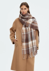 Detail of khaki plaid scarf with tassels and handmade label on wool coat for winter