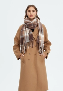 Detail of classic khaki plaid scarf with fringe paired with wool coat texture