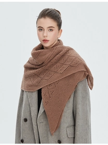 Gros plan sur un châle en tricot marron avec motifs ajourés et texture en laine