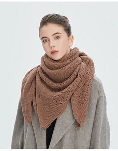 Détail d'une écharpe triangle en tricot marron sur un manteau de laine gris