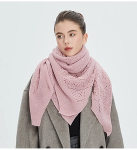 Détail d'une écharpe en maille rose avec motifs ajourés délicats et bords ondulés
