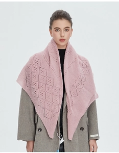 Détail d'une écharpe en maille rose avec motifs losanges ajourés sur un manteau gris