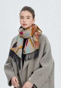 Détail d'une écharpe d'hiver aux motifs géométriques colorés et longues franges bleues