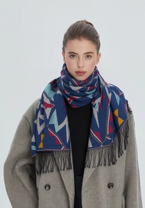 Détail d'une écharpe bleu foncé à motifs géométriques avec des franges noires denses