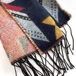 Gros plan d'une écharpe en jacquard aux motifs géométriques colorés et franges noires