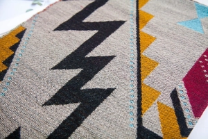 Vue macro d'un motif tissé géométrique ethnique avec franges sur un châle d'hiver doux