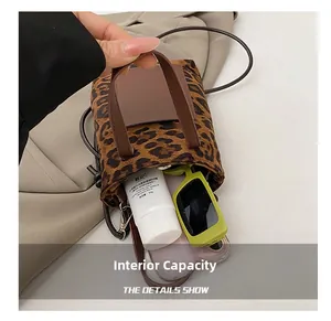 Internal capacity of leopard print mini bucket bag showing phone and sunglasses
