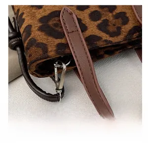 Detail of premium silver rotating metal hook and brown leather strap on leopard print bag